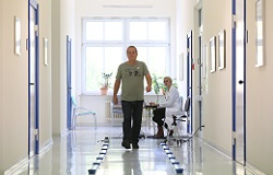 Frau läuft in einem Gang auf einem markierten Weg in der Orthopädie der Uniklinik Rostock