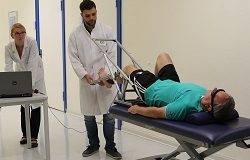 Patient auf Liege, Arzt übt das Strecken des Beines mit ihm in der Orthopädie der Uniklinik Rostock