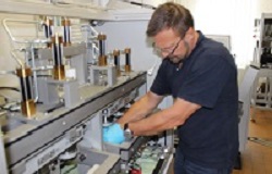 Mann im blauen T-Shirt arbeitet an einem Prüfgerät in der Orthopädie der Uniklinik Rostock
