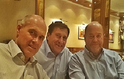 drei Männer im Hemd sitzen in einem Restaurant